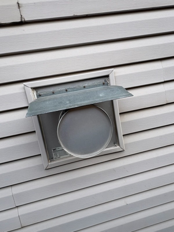 Exterior dryer vent hood installed on house siding by Calgary Repairs