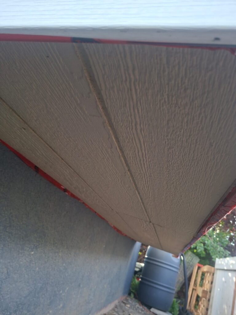Painted exterior wood paneling with sealant along the trim edge by Calgary Repairs
