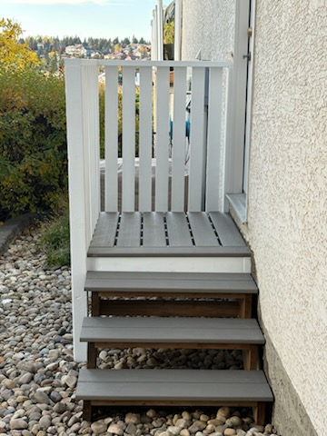 Painted wooden stair railing on exterior deck stairs in Calgary by Calgary Repairs