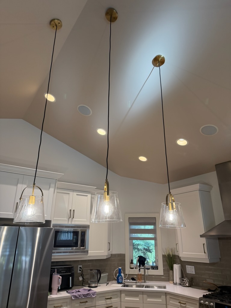 Three new pendant lights installed over a kitchen island in a Discovery Ridge home by Calgary Repairs